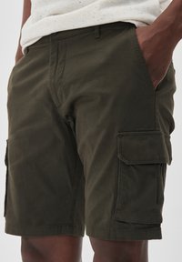 Olivově zelené cargo šortky vyrobené z lehké bavlny, s bočními kapsami a volným střihem. Obsahují šité švy a plochý přední díl.