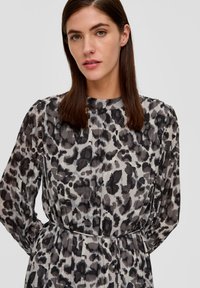 Langärmliges Kleid aus translucentem Stoff mit einem grau-schwarzen Tierdruck, tailliert und mit einem plissierten Design.