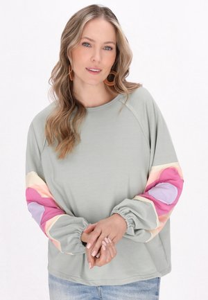 Sweatshirt verde deschis cu manșete elastice, prezentând mâneci cu un model multicolor în nuanțe de roz, crem și mov. Material moale și casual.