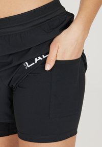 Zwarte sportshorts met een omgevouwen tailleband, met een zijzak en een witte logodetail op het been. Glad, elastisch materiaal.