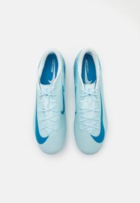 Botas de fútbol sintéticas de color azul claro con una superficie texturizada, cordones blancos y acentos azules. Presenta un prominente swoosh de Nike en cada zapato.
