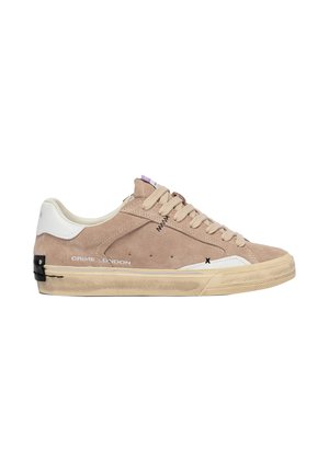 Sneaker beige in suede a bassa altezza con linguetta posteriore bianca, lacci beige, cuciture nere sottili e suola in gomma beige consumata.