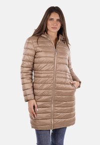 Cappotto invernale imbottito beige con cuciture orizzontali, chiusura zip e cappuccio. Presenta due tasche laterali e una texture liscia e lucida.