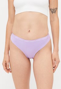 Λιλά βαμβακερά μπικίνι εσώρουχα με απαλό υφή και χαμηλή μέση σχεδίαση· διαθέτει μια διακριτική λογότυπο ταινία στη ζώνη.