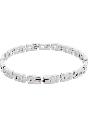 Bracelet à maillons en métal argenté avec des maillons rectangulaires creux et un petit détail rouge, blanc et bleu sur un maillon.