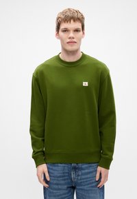 Sweatshirt de gola redonda em verde oliva com punhos e decote canelados. Inclui um pequeno patch retangular de logotipo no peito.