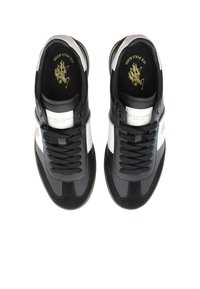 Czarno-białe sneakersy z gładką skórzaną cholewką, zamszowymi akcentami, płaskimi sznurówkami, gumową podeszwą oraz detalem logo na języku i boku.