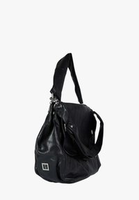 Borsa a tracolla in pelle nera con design morbido, dotata di una tracolla lunga, dettagli in metallo argentato e una piccola patch con il logo sul davanti.