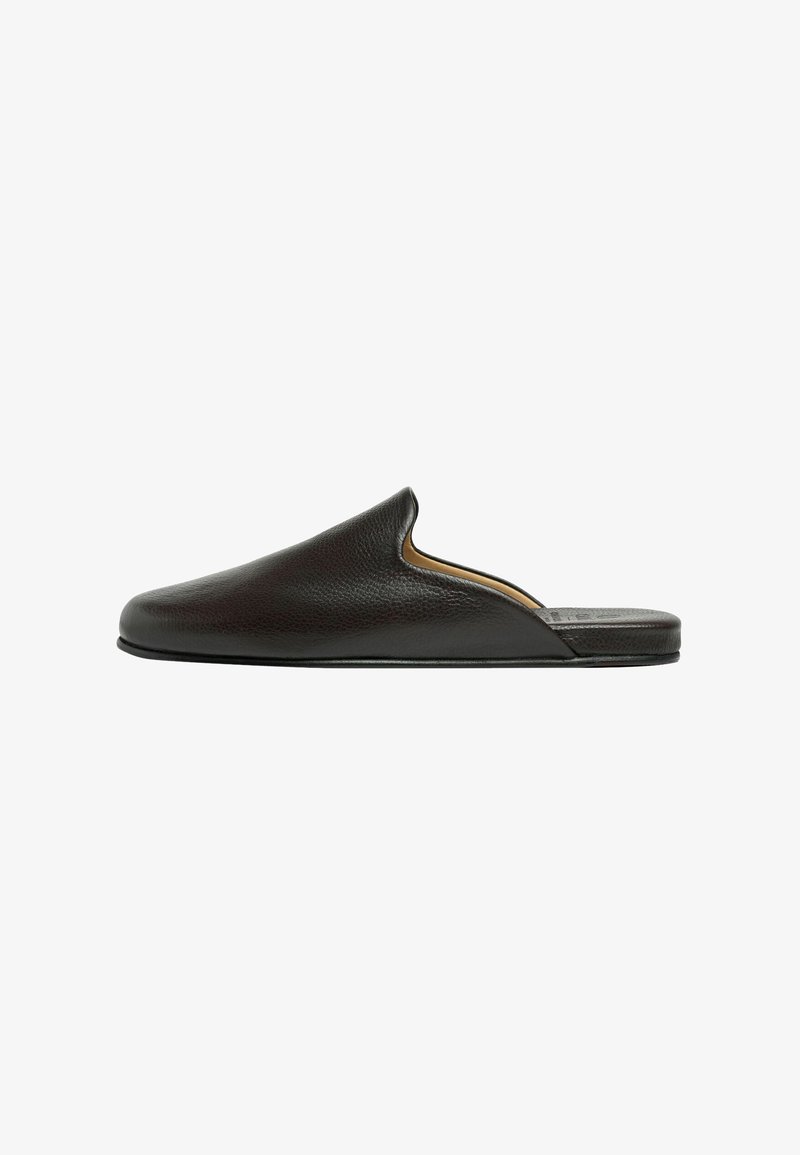 Mule en cuir noir à enfiler avec bout arrondi fermé et semelle plate, vue de côté sur fond blanc.