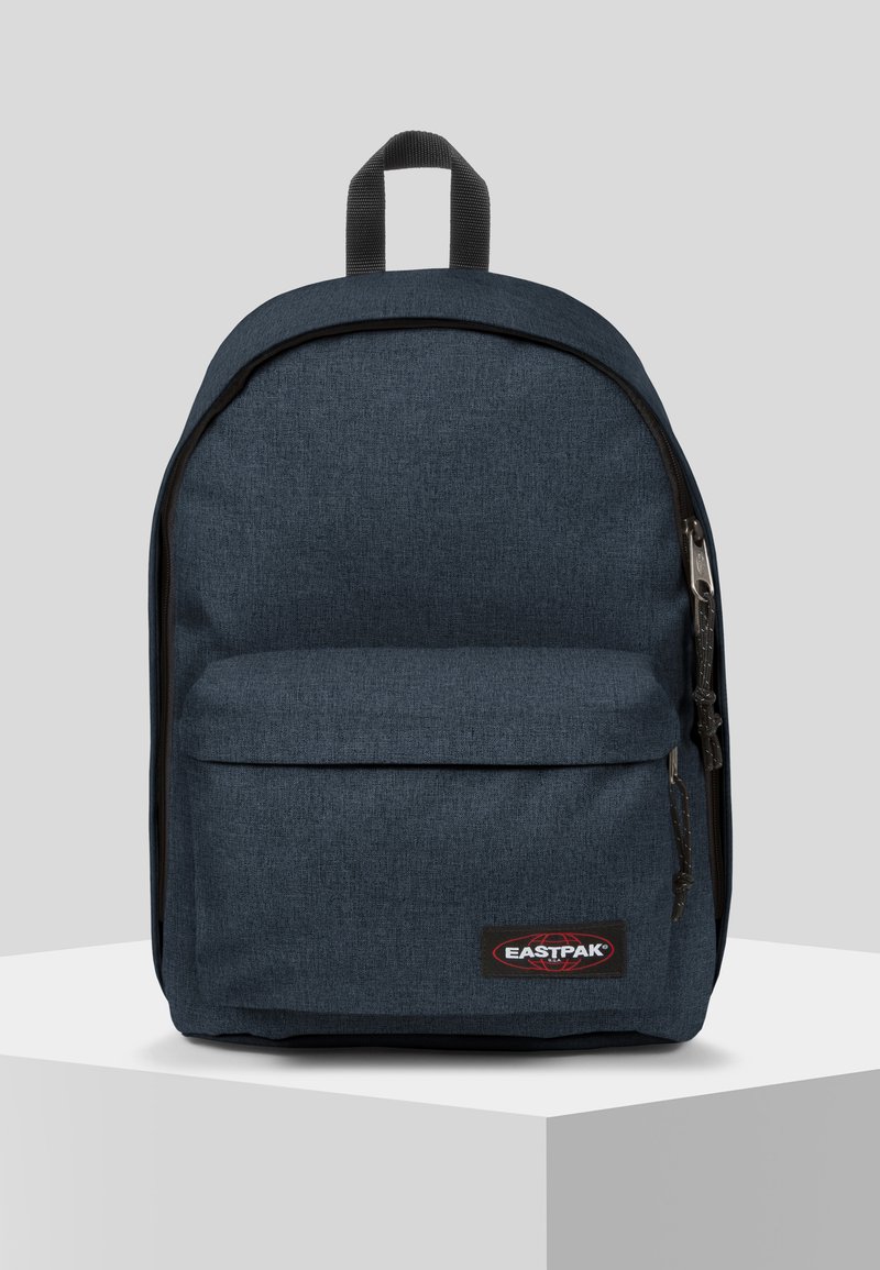 Tummansininen Eastpak-reppu, jossa on teksturoitu pinta, etutasku ja mustat vetoketjun yksityiskohdat. Kestävä kangas ja lenkki kahva päällä.