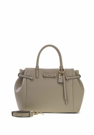 Sac à main en cuir beige avec deux poignées, garnitures dorées, pompons décoratifs et bandoulière détachable à côté sur fond blanc.