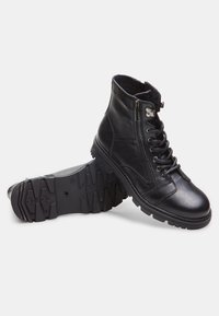 Botine negre din piele cu un finisaj texturat, șireturi și fermoar lateral; talpă din cauciuc rezistentă, cu un model de profil pronunțat.