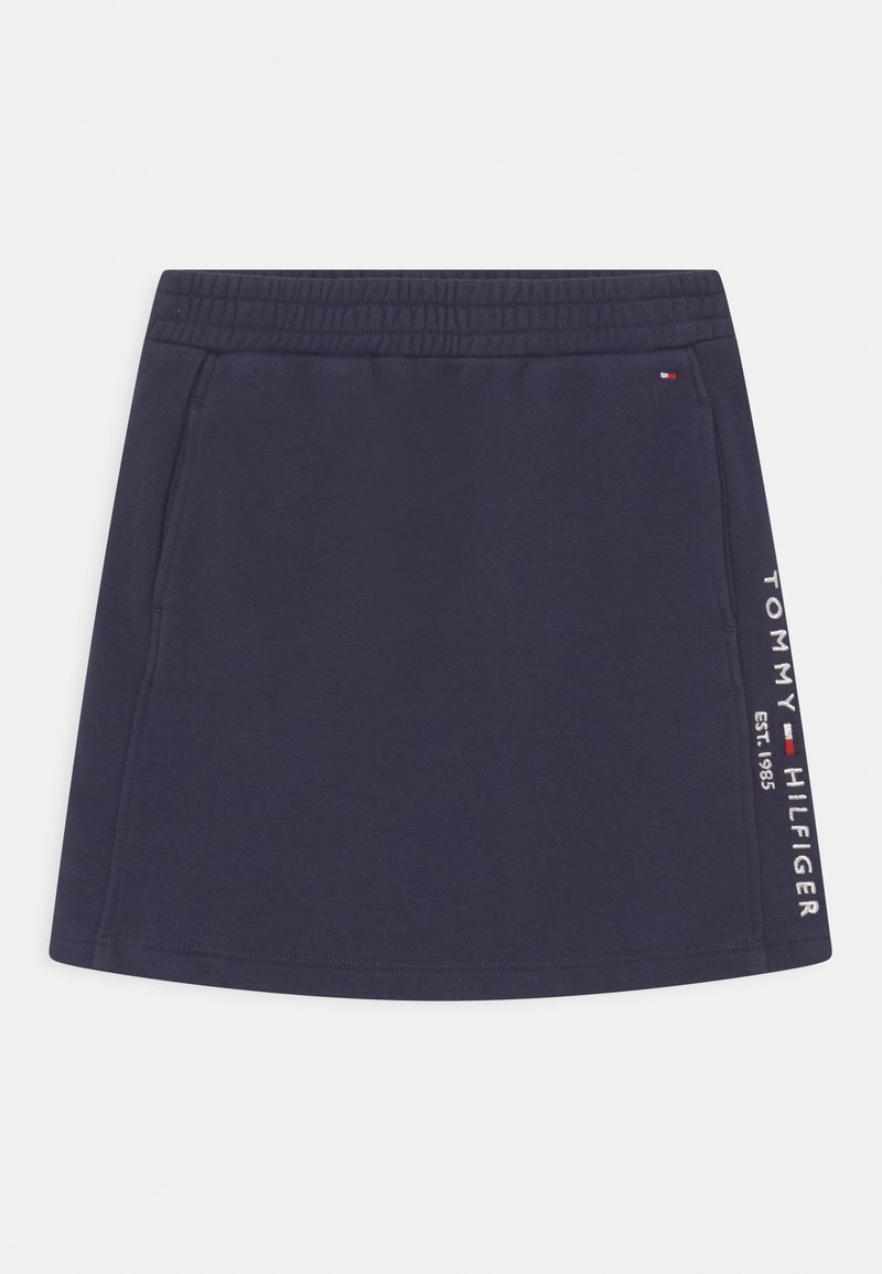 Jupe bleu marine avec ceinture élastique, texture lisse, arborant le texte blanc "TOMMY HILFIGER EST. 1985" sur le côté et des accents de logo.