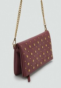 Borsa in pelle bordeaux con dettagli dorati a pois, design pieghevole e tracolla in oro. Tasca con zip alla base.