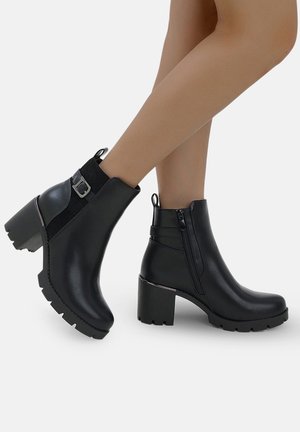 Zwarte enkelboots van soepel leer met een blokhak, ritsluiting, zijaccenten en een robuuste zool.