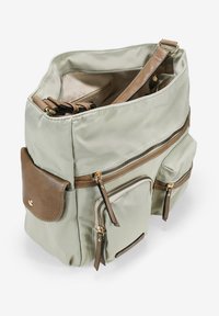 Bolsa de nailon verde con múltiples bolsillos con cremallera, acentos de cuero marrón y una correa de hombro desmontable. El interior incluye un organizador.