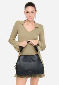 Melnas ādas rokassoma ar teksturētu virsmu, zelta tonētiem aksesuāriem un ieaustām rokturim, kurā priekšpusē ir izkaltās zīmola nosaukums "LIU JO".