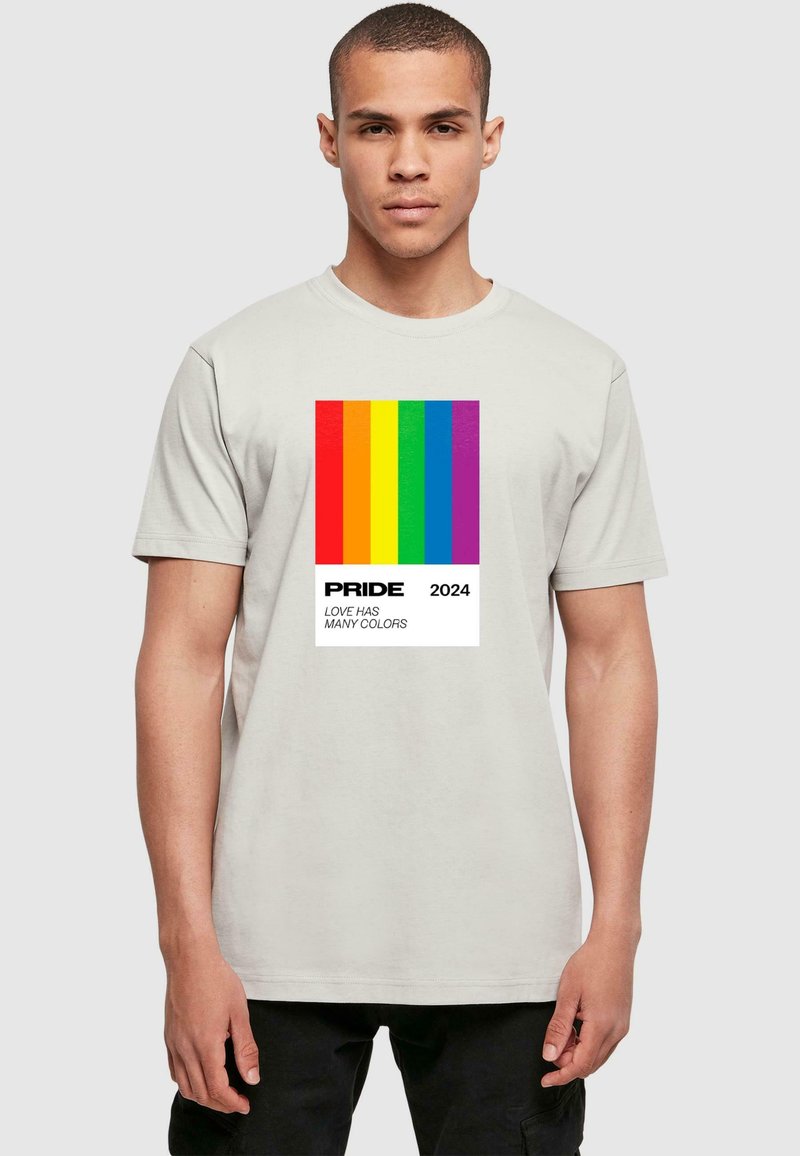 Šviesiai pilkas marškinėlių trumpomis rankovėmis dizainas su spalvingais vaivorykštės juostų piešiniais priekyje, o žemiau užrašas "PRIDE 2024" ir "MEILĖ TURI DAUG SPALVŲ".