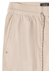 Pantalon beige avec taille élastique, poches latérales, cordon avec des pois noirs et une petite étiquette noire indiquant "CECIL" à la taille.