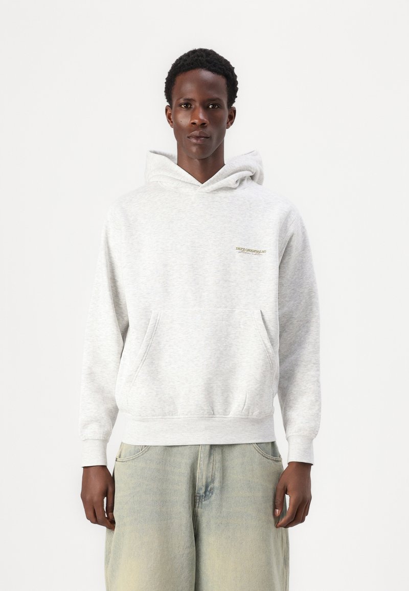 Grå hettegenser med frontlomme, myk tekstur og en liten logo på brystet. Har hetta med snor og ribbestrikkede mansjetter. Bæres med lyse jeans.