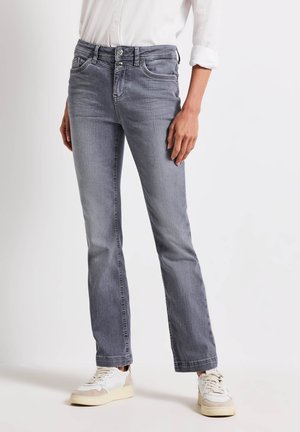 Grijze denim jeans met een rechte pasvorm, voorzien van een dubbele knoopsluiting, vijf zakken en subtiele stikdetails. Gecombineerd met witte sneakers.