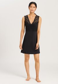 Vestaglia nera con scollo a V profondo decorato con pizzo e spalline standard. Tessuto liscio con vestibilità comoda.