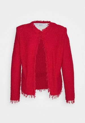 Chaqueta roja de textura abierta con bordes con flecos en el cuello, puños y dobladillo, mostrada sobre un fondo blanco liso.