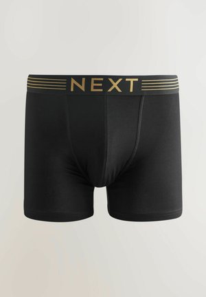 Mustad mustad bokserid, mis on valmistatud elastsest kangast, millel on kuldne logo-trükk ja horisontaalsed triibud vööl. Sile tekstuur, keha lähedane disain.