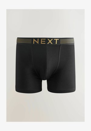 Boxer-briefs noirs en tissu extensible, avec une ceinture imprimée du logo doré et des rayures horizontales. Texture lisse, design ajusté.