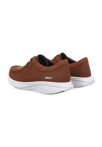Scarpe in suede marrone con suola in gomma bianca, punta rotonda e dettagli di cucitura minimi. Presentano il marchio MBT sul lato.