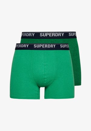 Grüne Baumwoll-Boxershorts mit einem marineblauen elastischen Bund, der mit "SUPERDRY"-Branding versehen ist. Die Vorderseite ist glatt mit minimalen Nähten und einer weichen Textur.