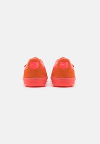 Zapatillas deportivas de ante en naranja con acentos en rosa, con un talón trasero liso y un diseño texturizado en los laterales.