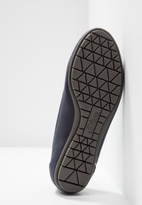 Semelle d'une chaussure bleu foncé avec un motif géométrique de la bande de roulement, taille 37, et le logo "s.Oliver" sur la semelle.