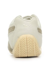 Jasnoszare zamszowe sneakersy z teksturowanymi akcentami, gumowa podeszwa z głębokim bieżnikiem i białe logo wyhaftowane z tyłu.