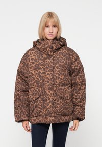 Hnědá puffer bunda s leopardím potiskem a kapucí, se stylovým prošívaným designem a dvěma předními kapsami. Měkká struktura a oversized střih.