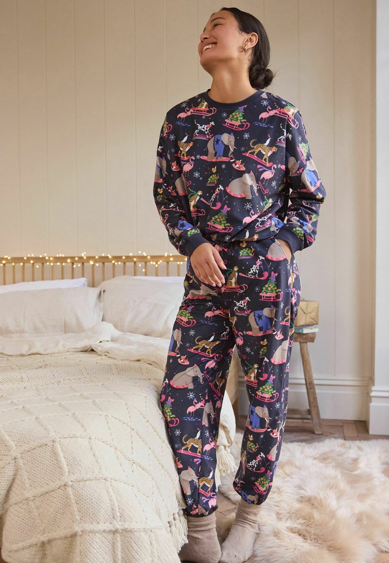 Marinblå pyjamasset med lekfulla djurmönster på ett mjukt tyg. Inkluderar en långärmad topp och matchande byxor med resår.