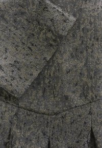 Țesătură texturată neagră și aurie, cu un model de forme abstracte, având un luciu moale și un efect de suprapunere în design.