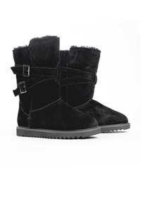 Botas de ante negras con un acabado texturizado, que presentan doble hebilla y una suela de goma estriada. La parte superior tiene un suave forro de pelo.