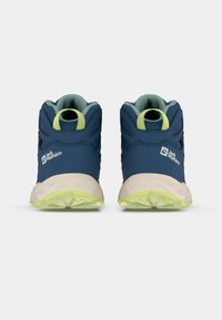 Încălțăminte de drumeție mid-top de culoare albastru închis cu accente negre, având o suprafață texturată, talpă verde deschis și mânere pe spate pentru o purtare ușoară.