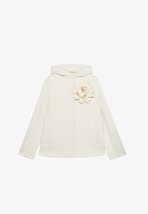 Veste à capuche blanche avec une finition texturée, arborant une application florale décorative sur le côté gauche et deux poches avant.