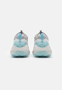 White and gray athletic shoes with light blue accents, textured soles, and pull tabs on the rear for easy wear.