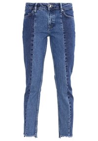 Farkut, joissa on kaksivärinen sininen design, suorat lahkeet, viimeistelemättömät lahkeet ja perinteinen viiden taskun malli.