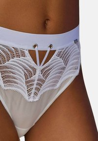 Weißes Spitzenunterwäsche-Set mit einem wellenförmigen Design, einem durchsichtigen Mesh-Einsatz und einem breiten Bund, akzentuiert mit silbernen Ösen und Bändern.