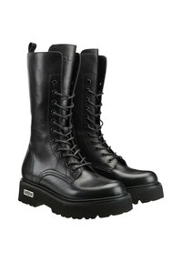 Stivali da combattimento in pelle nera con gambale alto, chiusura con lacci e suola piatta spessa. Presentano linguette e dettagli del nome del marchio in rilievo.