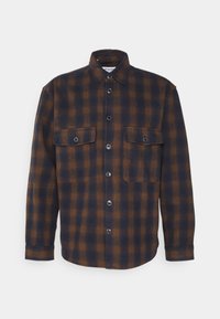 Brun och marinblå rutad skjorta i flanell; har en klassisk krage, knappstängning fram, två bröstfickor och långa ärmar.