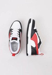 Sneakers con una combinazione di colori bianco, nero e rosso; tomaia sintetica, punta perforata, design con lacci e colletto imbottito. Presentano un accento rosso.