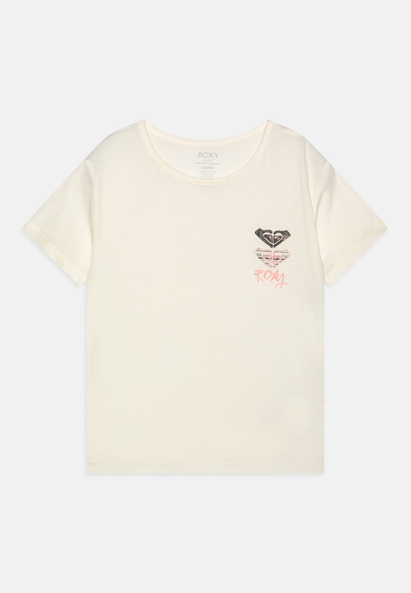 Camiseta de algodón color crema con mangas cortas. Presenta un estampado de un diseño de corazón estilizado en negro y rosa en el lado izquierdo del pecho.