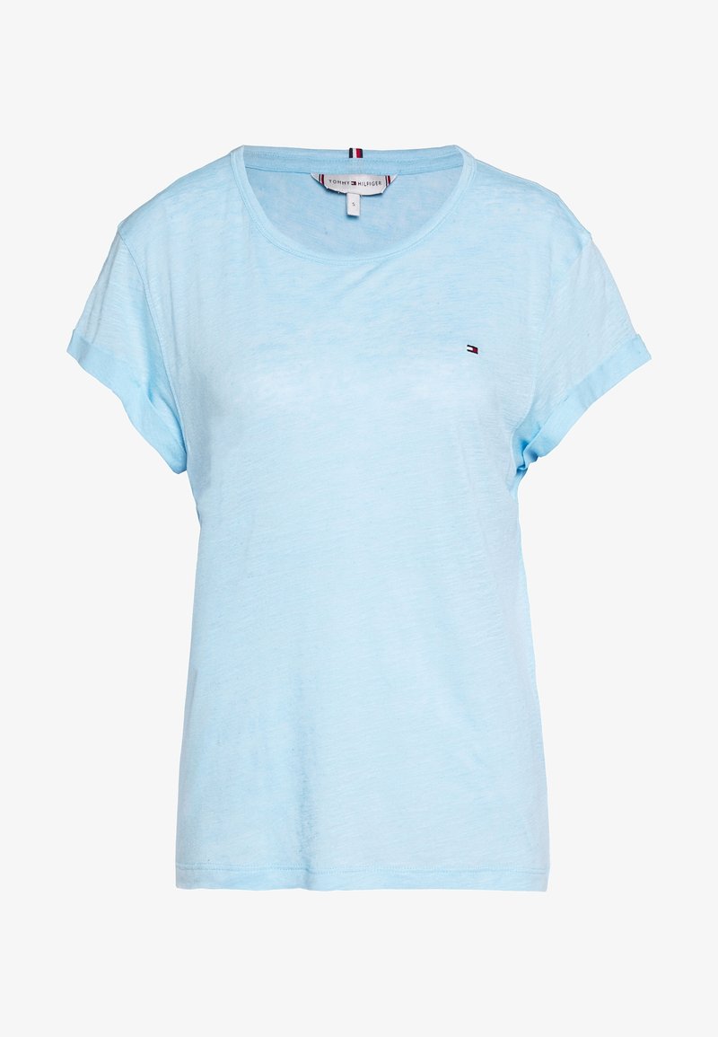 Camiseta de manga corta de color azul claro, hecha de una tela suave y texturizada. Presenta un pequeño logo en el lado izquierdo del pecho y un diseño de ajuste relajado.