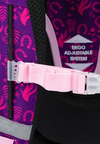 Tessuto viola con motivi floreali rosa e ferro di cavallo, dotato di una tracolla regolabile rosa e di una clip di plastica per fissare il sistema di imbracatura.