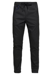 Czarne spodnie dresowe z teksturowanej tkaniny, wyposażone w ściągacz w talii, boczne kieszenie na zamek oraz ozdobny niebieski metalowy pierścień.